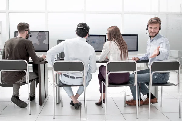 Achteruitkijk. de operators van het business center zitten aan een bureau — Stockfoto