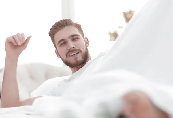 Primer plano. Hombre sonriente descansando en el dormitorio — Foto de Stock