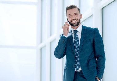 Kapat. Gülümseyen iş adamı telefonda konuşuyor.