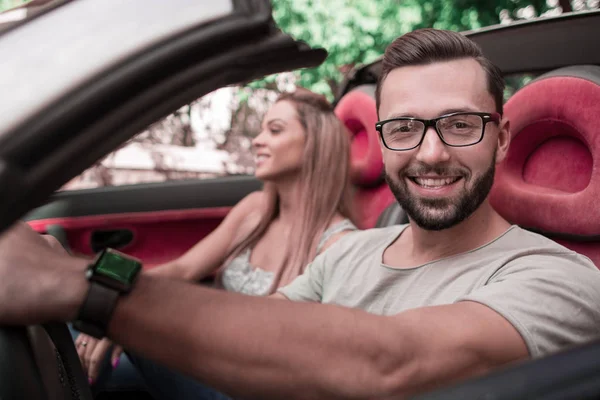Close up.stylish homem com sua namorada viajando em um carro conversível . — Fotografia de Stock