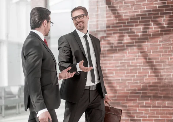 Två leende affärsman promenader i office hall — Stockfoto