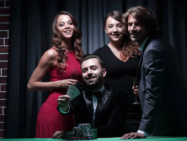 Adult group celebrates a friends victory in poker — Stock Photo, Image
