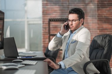 İş adamı cep telefonuyla konuşuyor.