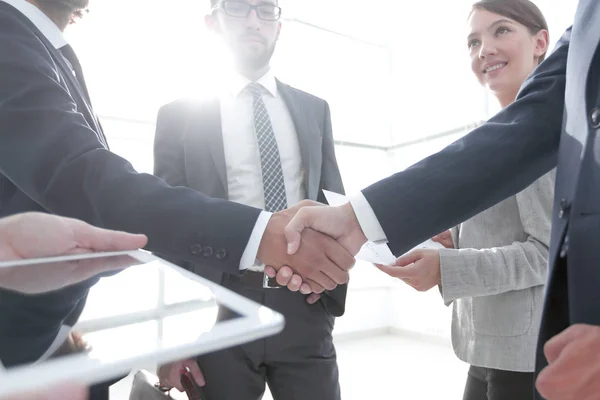 Employees look at the handshake business partners — Stock Photo, Image