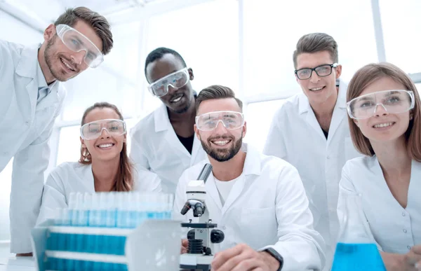 Grupo de jovens clínicos experimentação em laboratório de pesquisa — Fotografia de Stock