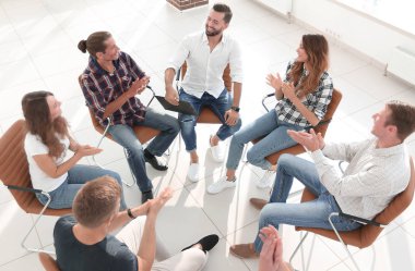 İş ekibi ofisin lobisinde bir toplantı düzenliyor.