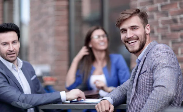 employees of the company sitting at a table in a street cafe