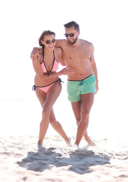 Giovane coppia che si tiene per mano e cammina sulla spiaggia. — Foto Stock