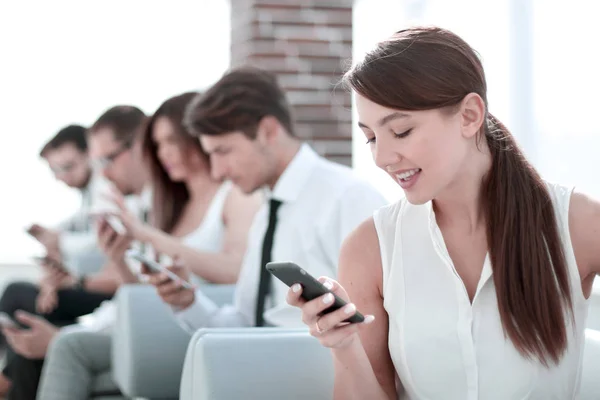 Joven empleado mirando el mensaje de texto en el teléfono inteligente — Foto de Stock