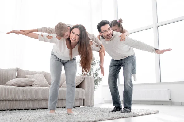 Pais amorosos brincando com crianças em sua casa — Fotografia de Stock