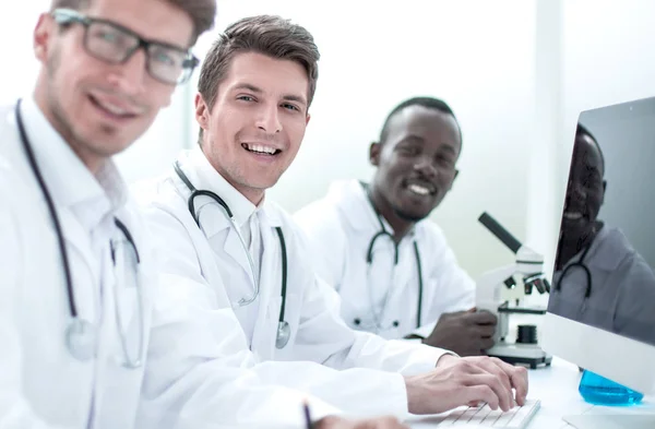 Team med läkare som sitter vid bordet laboratorium — Stockfoto