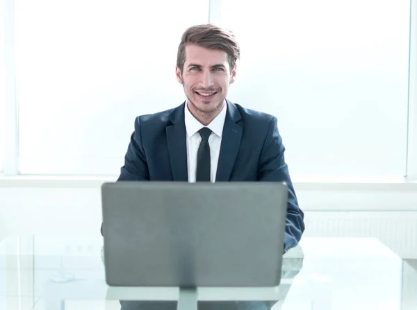 Selbstbewusster Geschäftsmann sitzt an einem Tisch in einem geräumigen Büro — Stockfoto