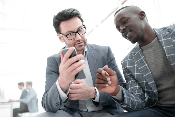 Två anställda tittar på smartphone skärmen — Stockfoto