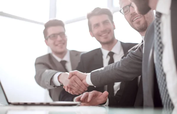Employees shaking hands sitting at the office Desk. — Stock Photo, Image