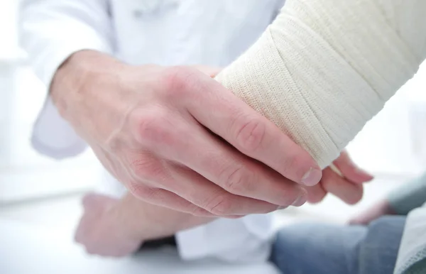 Ortopedista aplicando vendaje a pacientes mano en clínica — Foto de Stock