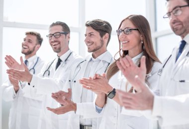 Bir grup başarılı doktor alkışlıyor.