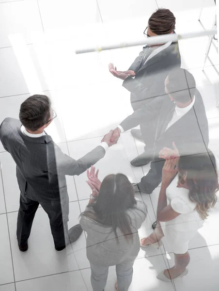 Handshake parceiros de negócios atrás da porta de vidro — Fotografia de Stock