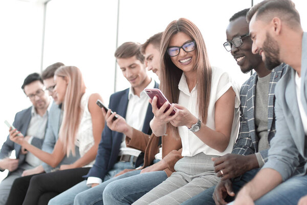 group of young people looking at the screens of their smartphones