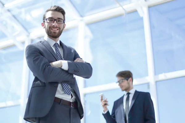 Leende affärsman på bakgrunden av ett modernt kontor — Stockfoto