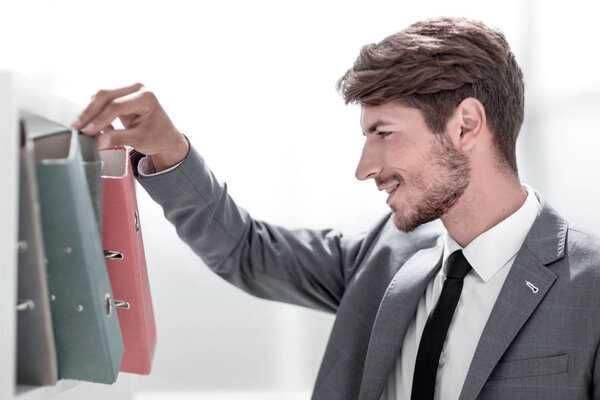 Молодой счастливый бизнесмен просматривает документы
