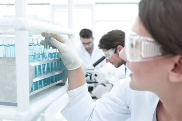 Jeune femme avec éprouvettes en laboratoire — Photo