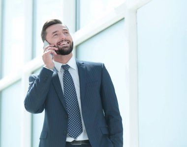 Gülümseyen iş adamı cep telefonuyla konuşuyor