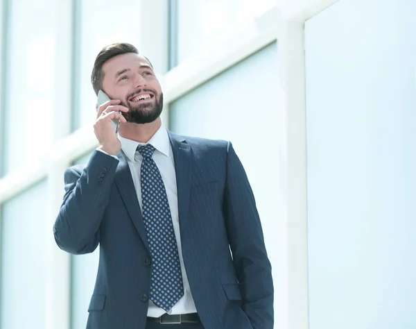 Hombre de negocios sonriente hablando en un teléfono móvil — Foto de Stock