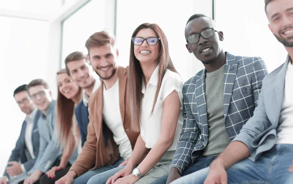 Unga människor som sitter på väggen väntar på sin tur vid intervjun — Stockfoto