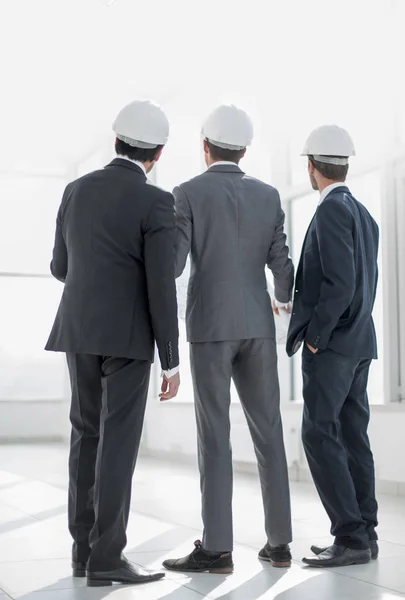 Vista trasera.tres arquitectos mirando el espacio de copia — Foto de Stock