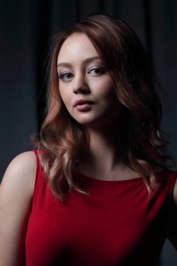 Siyah bir arka plan üzerinde poz Kırmızı elbiseli çekici esmer.