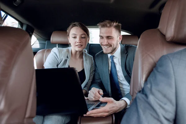 Close up.business colleagues discuss business issues sitting in the car — Stock Photo, Image