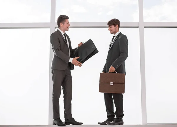 Colegas de negocios de pie cerca de una gran ventana de oficina . — Foto de Stock