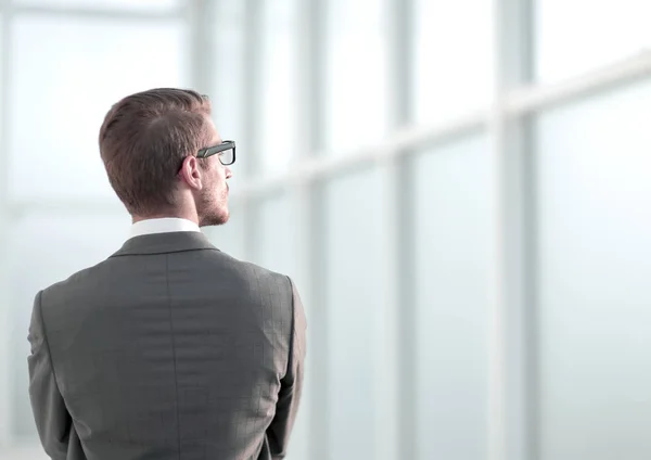 Πίσω όψη.επιχειρηματίας στέκεται κοντά στο παράθυρο του γραφείου — Φωτογραφία Αρχείου