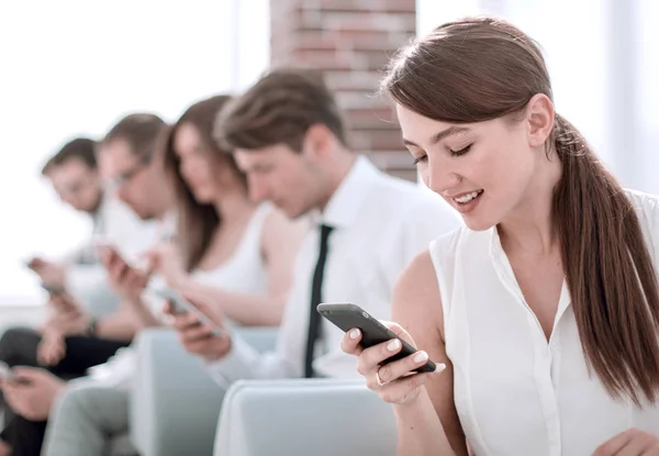 Joven empleado mirando el mensaje de texto en el teléfono inteligente — Foto de Stock