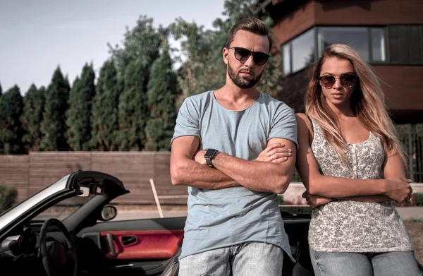 Jeune couple debout près de voiture de luxe . — Photo