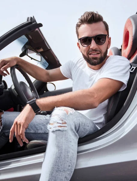 Close up.stylish junger Mann sitzt in einem Luxusauto — Stockfoto