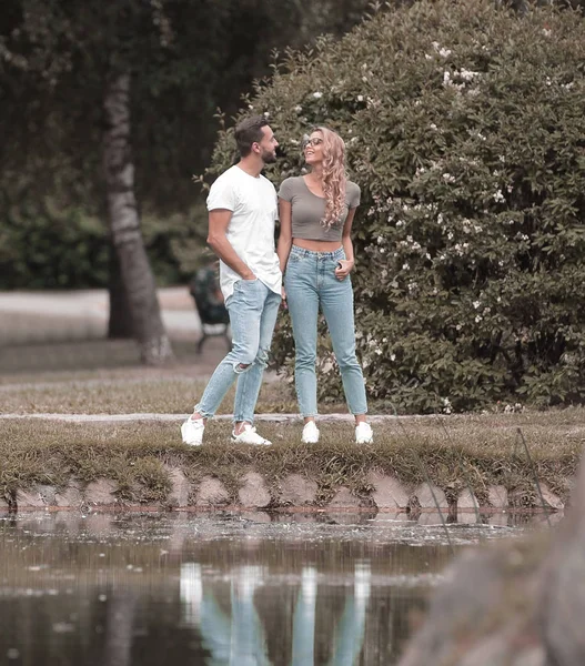 couple in love standing on the grass near the lake