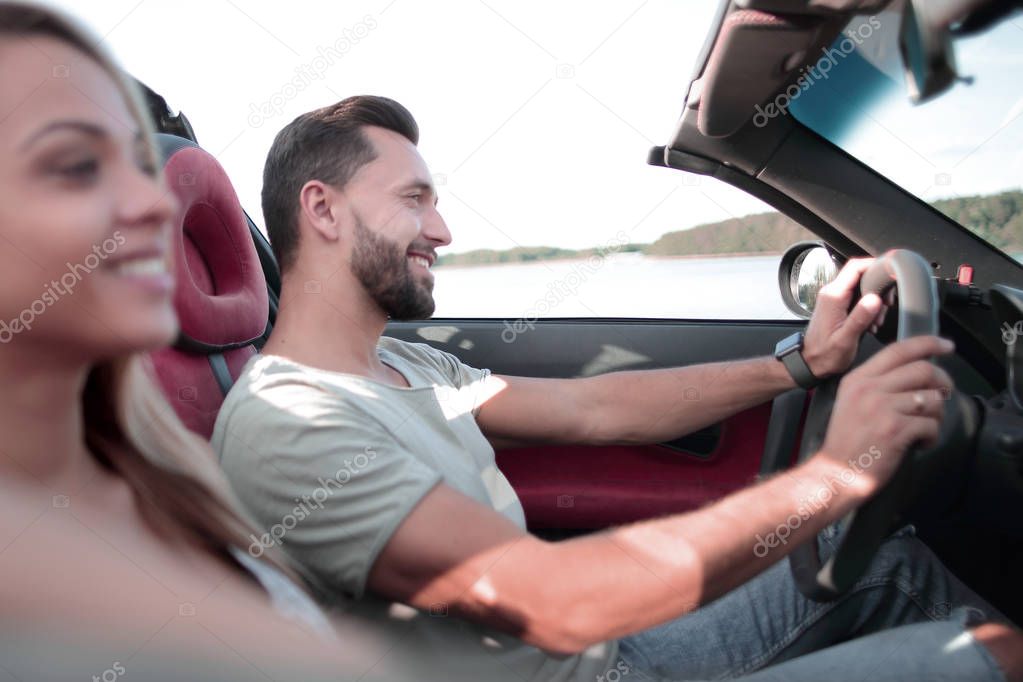 close up.smiling couple sitting in a convertible car