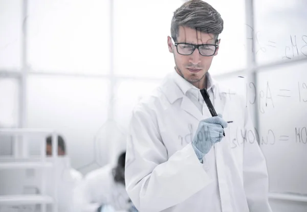 Wetenschapper maken van notities op het glas bestuur ten tijde van het experiment — Stockfoto