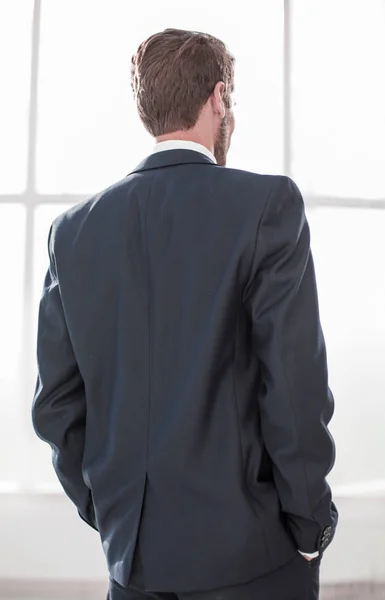 Vue arrière.homme d'affaires regarde par la fenêtre du bureau — Photo