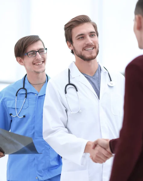 Médico sonriente estrechando la mano de un paciente —  Fotos de Stock