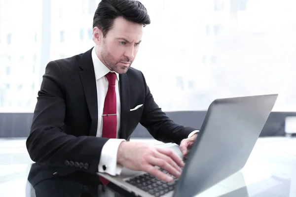 Biznesmen piszący na laptopie, siedzący przy biurku — Zdjęcie stockowe