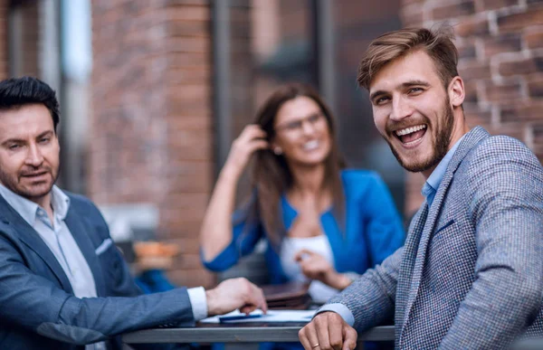 Empleados de la empresa sentados en una mesa en un café de la calle — Foto de Stock