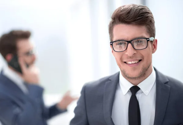 Close up. smiling young businessman in the office background — стоковое фото