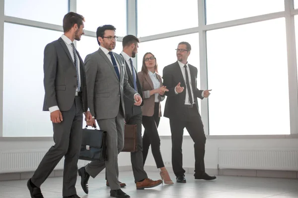 Affärsmän promenader i kontorsbakgrund. — Stockfoto