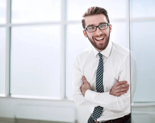 Uomo d'affari sorridente in piedi vicino alla finestra dell'ufficio . — Foto Stock