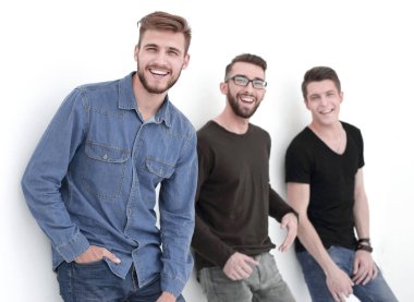 üç kişi duvara yaslanmış gülümseyen