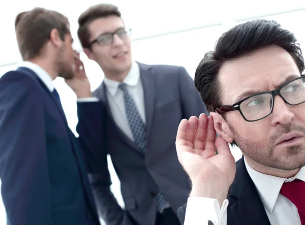 Close up.businessman eavesdropping on conversation between colleagues — Stock Photo, Image
