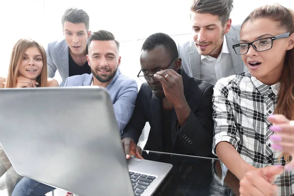 Jóvenes colegas mirando a la computadora portátil con sonrisa en la cara — Foto de Stock