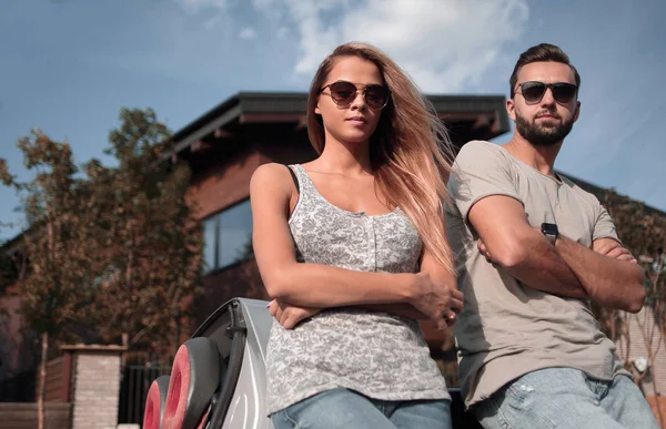 Untere Ansicht. Schönes Paar steht neben einem Cabrio — Stockfoto
